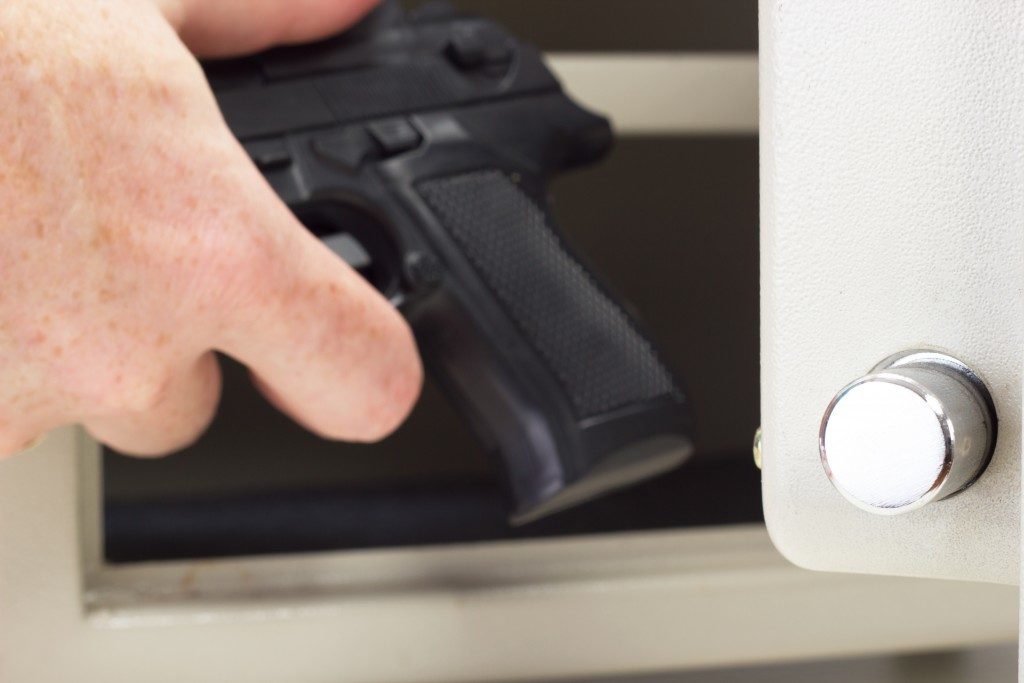 Person putting a firearm in a safe