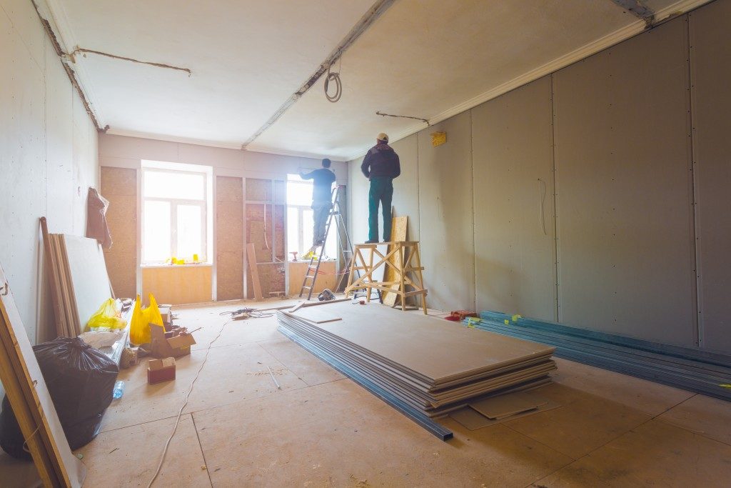 Workers installing plasterboard walls
