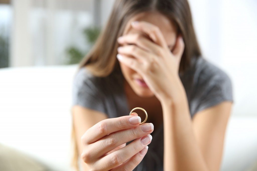 woman crying while holding a ring