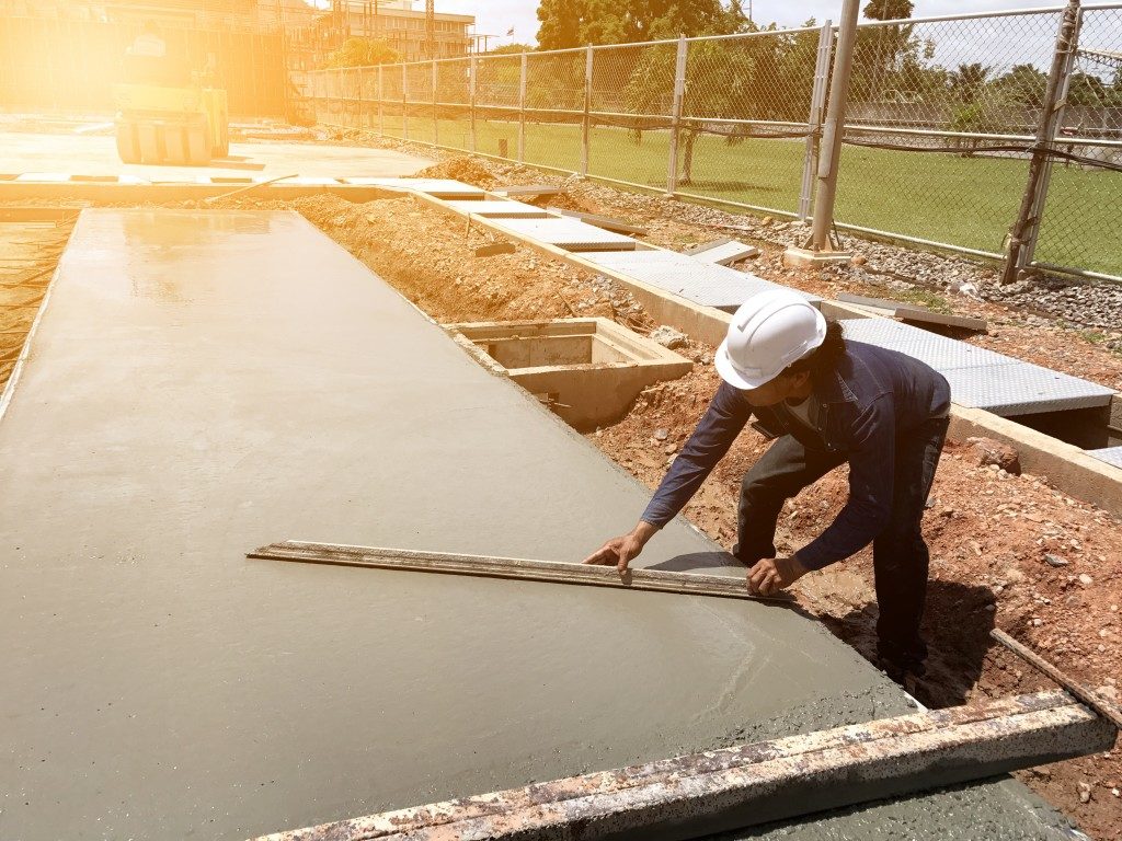 Worker spreading concrete mix construction