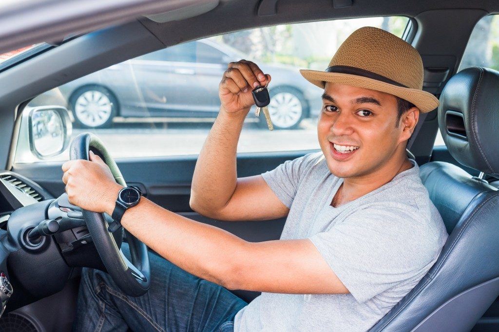 Man holding out keys to new car