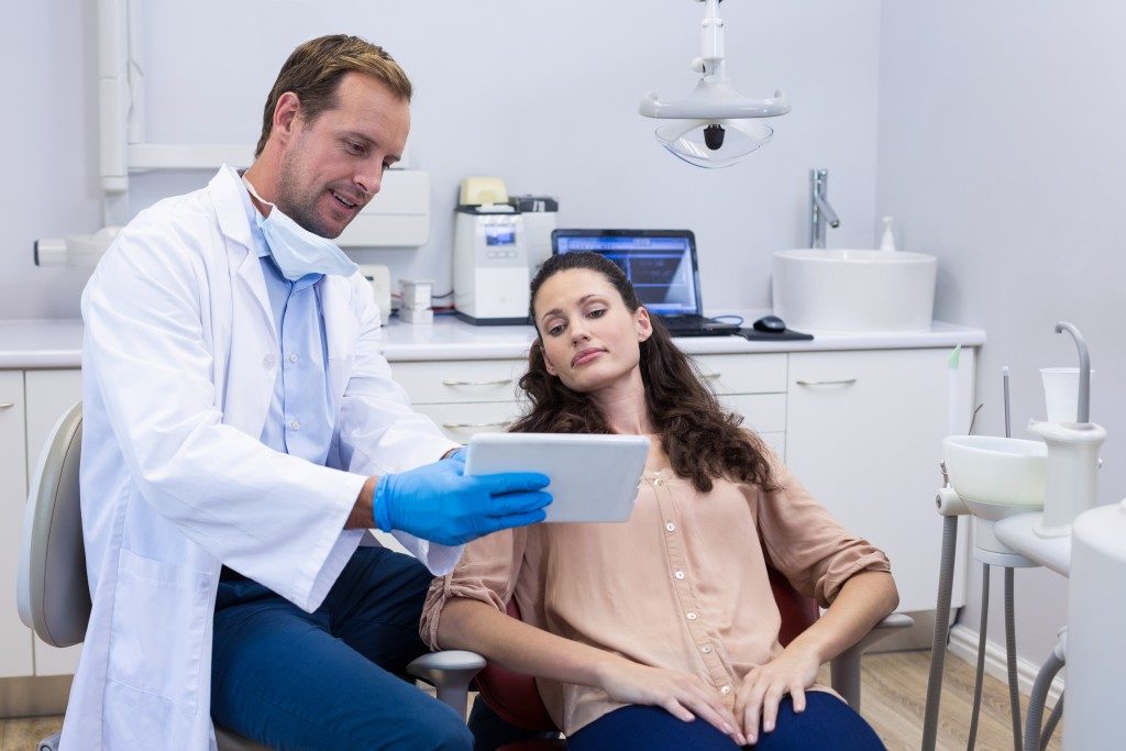 dentist discussing some information with his patient