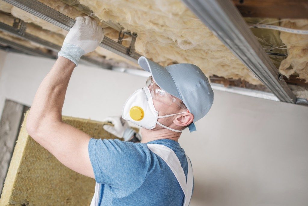 man installing insulation in a home