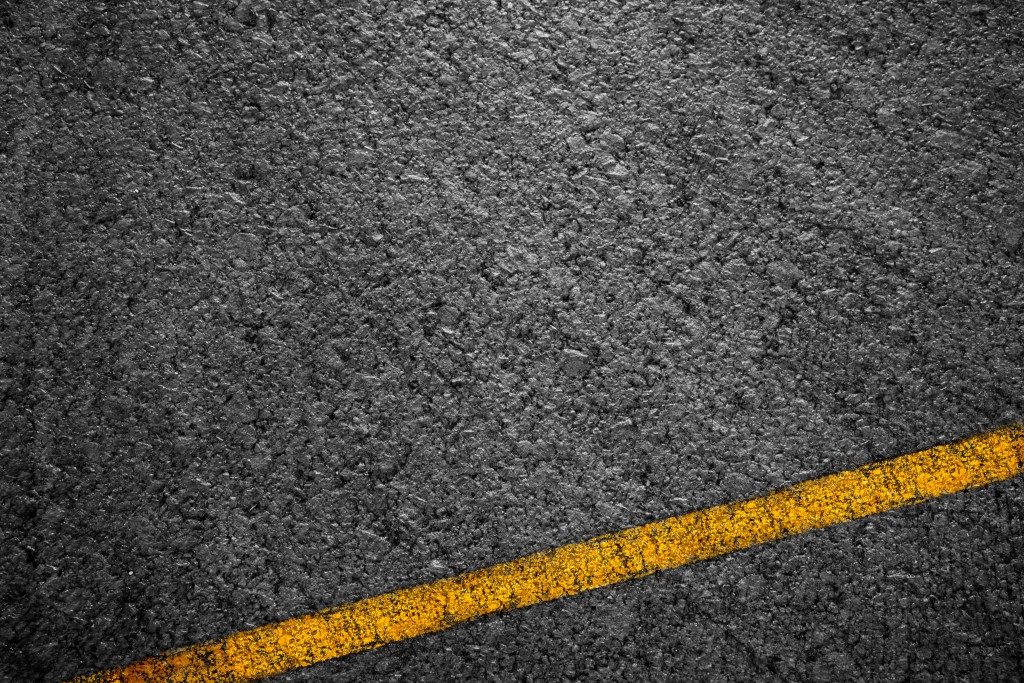Asphalt background texture with some fine grain with Yellow Stripe