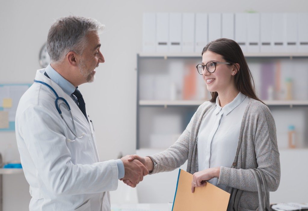 Doctor shaking hands with female patient