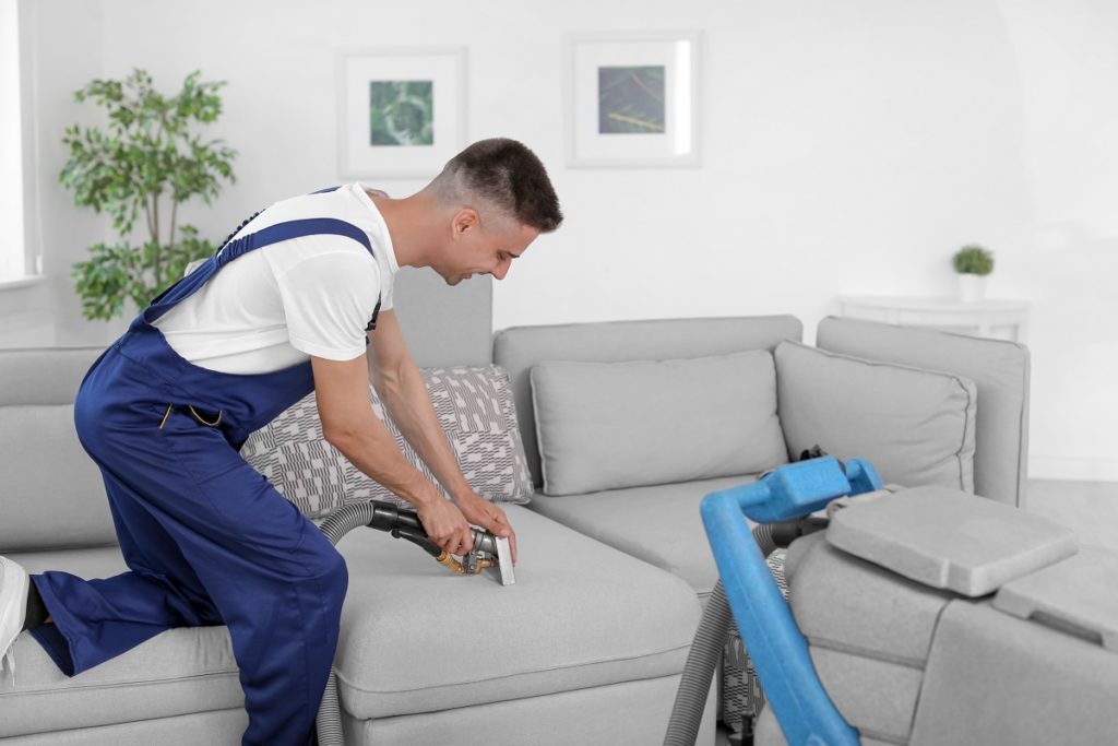 man cleaning couch