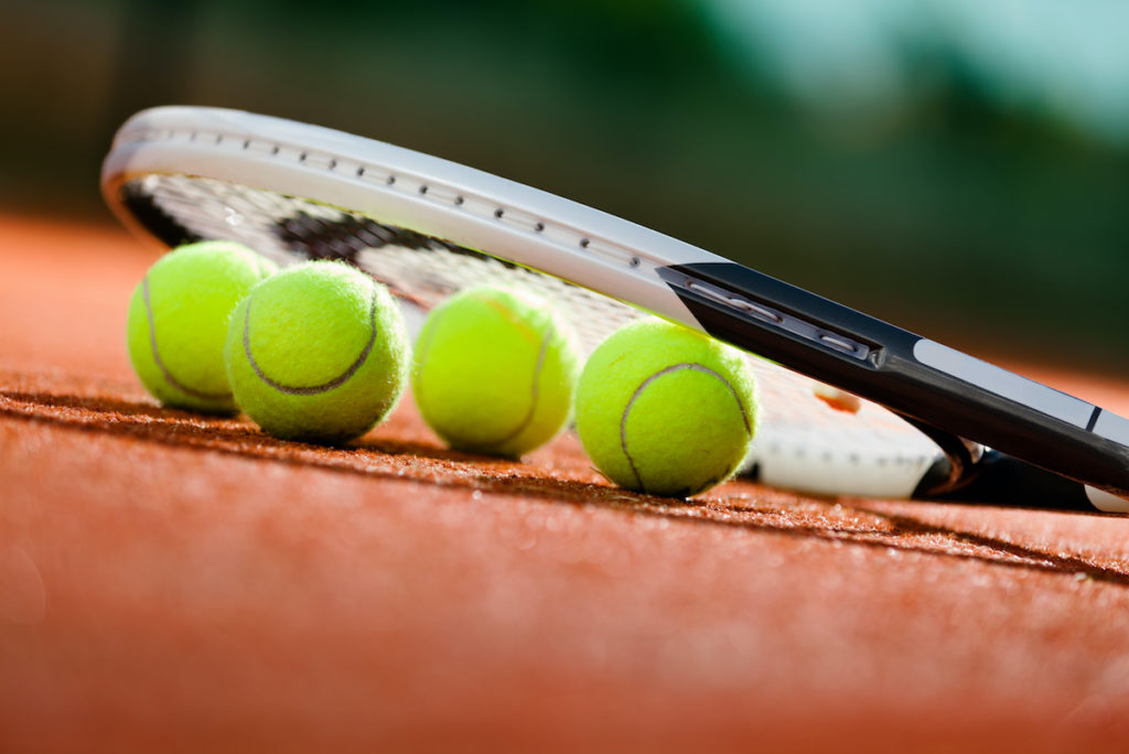 tennis balls under the racket