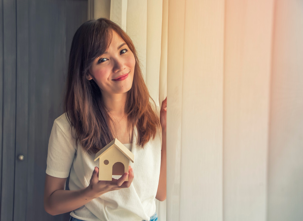 woman holding small house