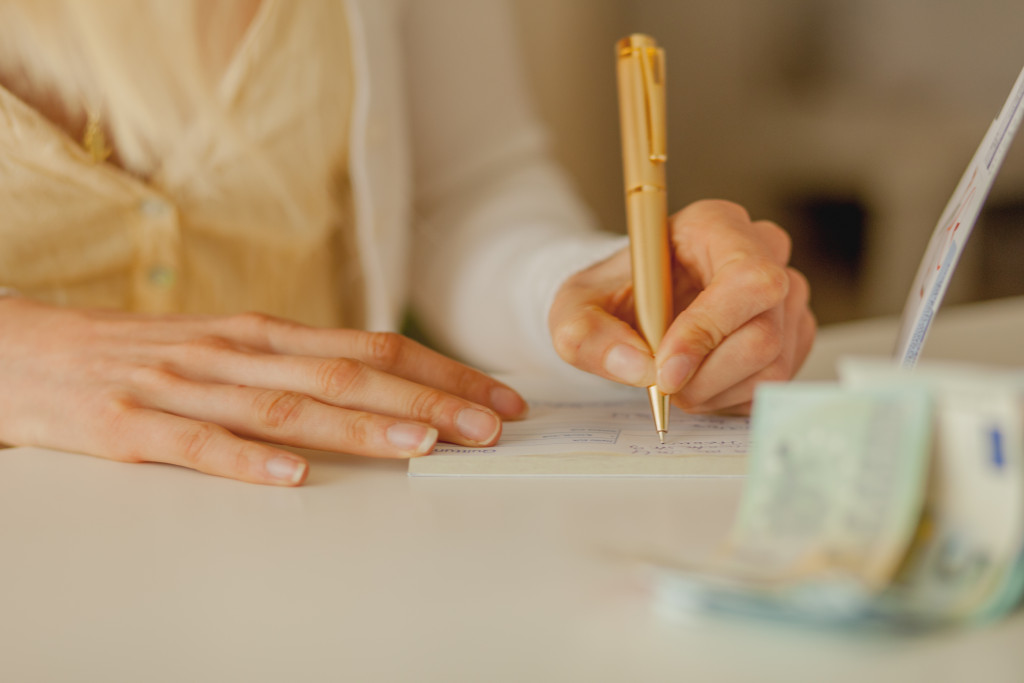 Woman writing, money is visible in the table