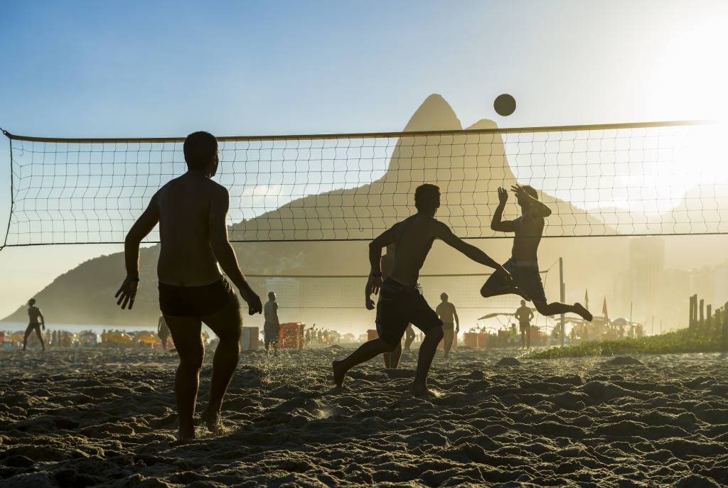 men playing beach volleyball outdoors