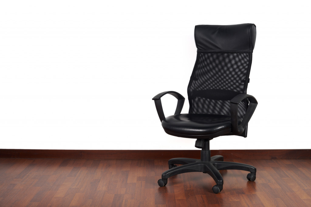 A black office chair on a wood floor