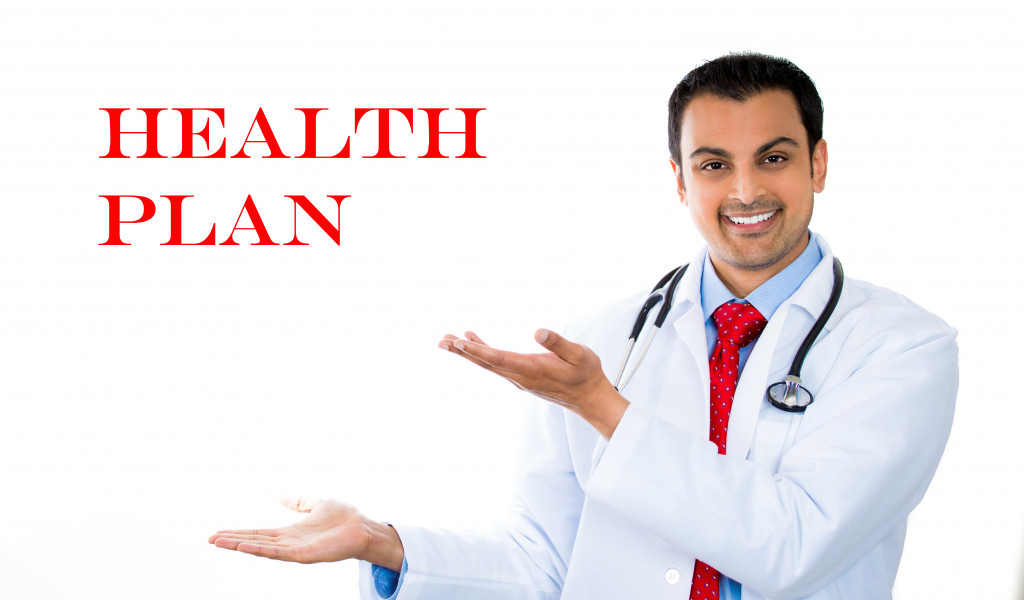 Closeup portrait of health care professional with stethoscope pointing to sign that says