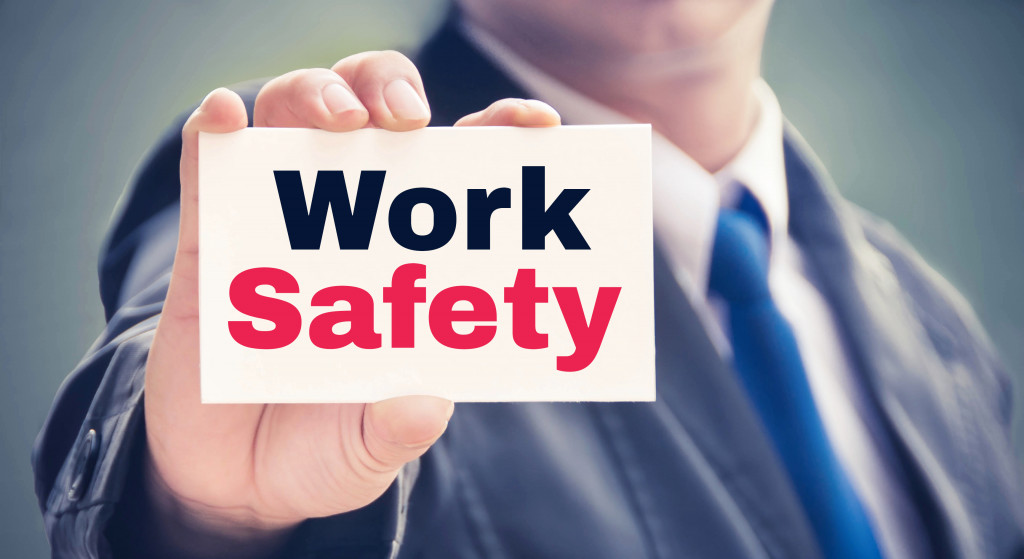 A businessman holding a Work Safety card