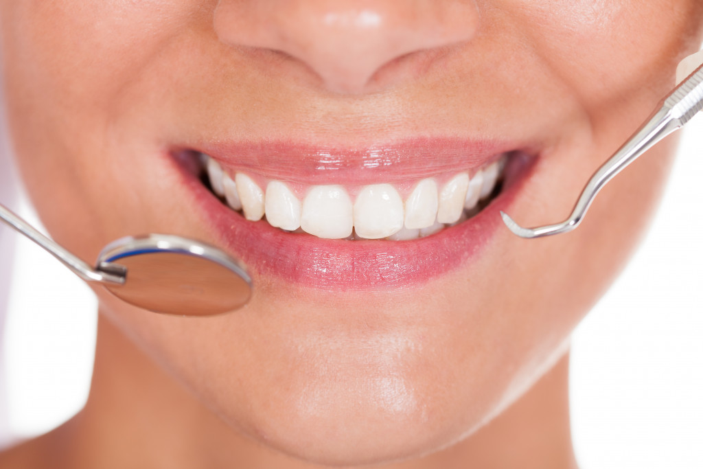 Dental tools near a smiling woman with white teeth
