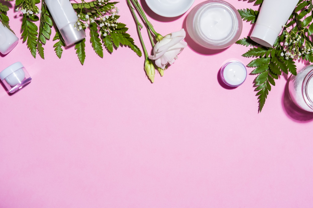 skincare products against pink backgrounds