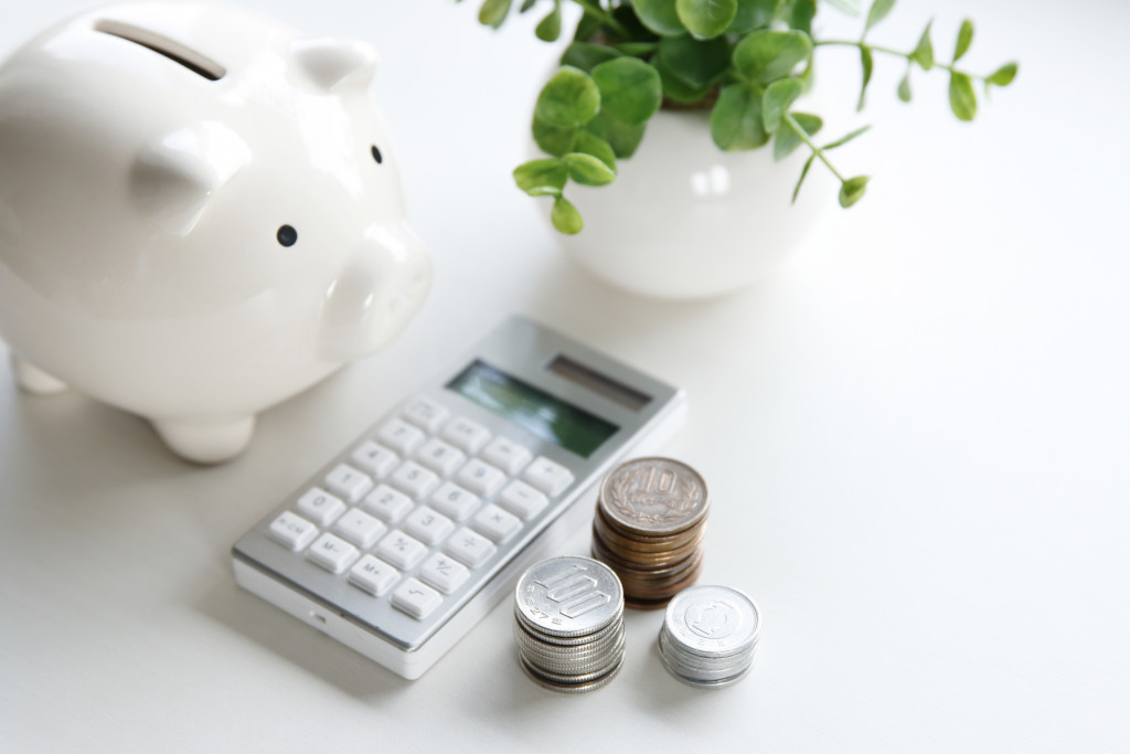 A piggy bank, calculator, and coins
