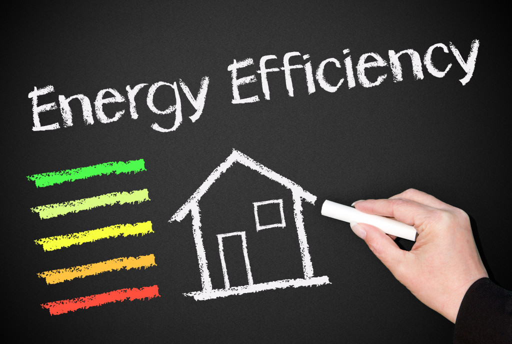 Drawing of a house on a chalkboard with the words energy efficiency above it and colored lines on the side.