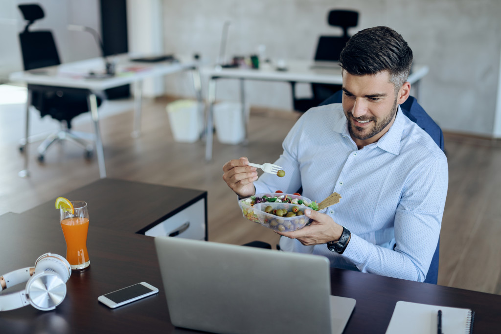 businessman working while eating healthy snack